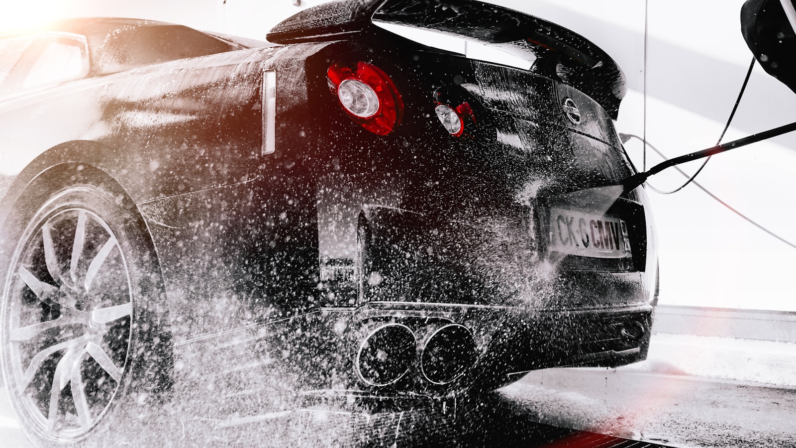 Water spraying off a ceramic coated black sports car